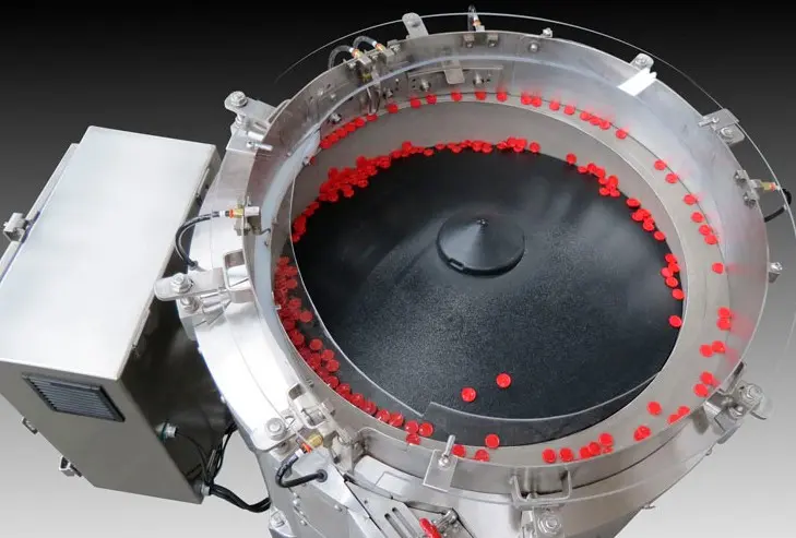 Centrifugal bowl feeder orientating small red plastic components at speed